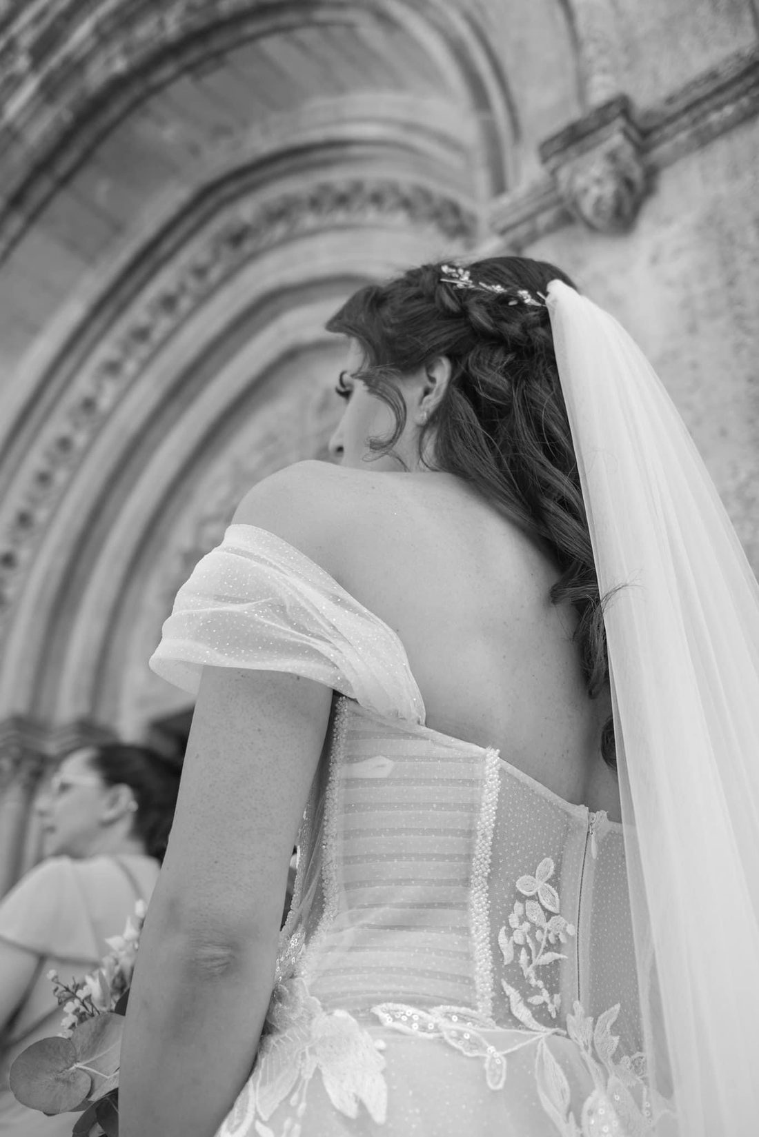 Mariée de dos devant l'église, noir et blanc, Studio Ayra